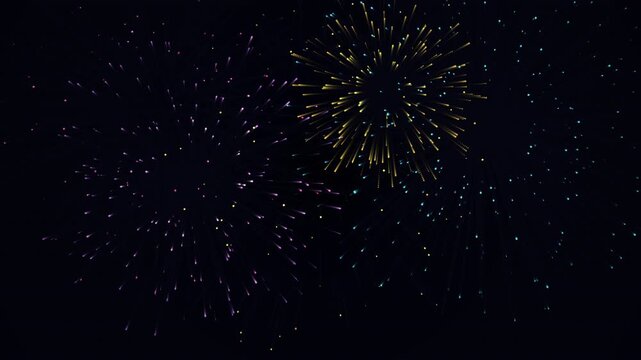 Holiday fireworks exploding in dark night sky abstract background