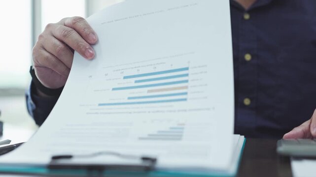 Analyst conducts financial analysis at work, reviewing analysis sheets finish market research, while detailed analysis reveals key corporate performance trends.