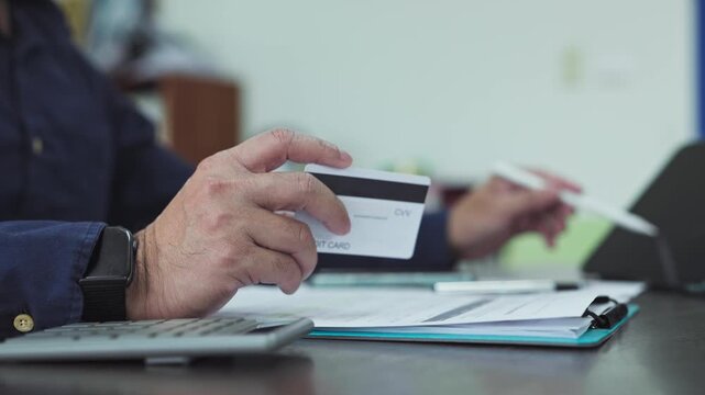 Online payment calculation requires careful payment verification as man handles payment processing alongside financial invoice balancing.