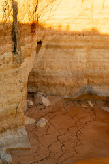 Golden cliff wall and orange sand beach with crack patterns © KetteCreate