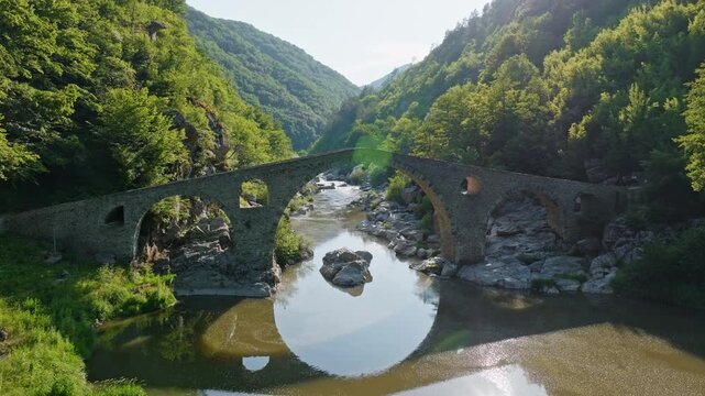 Devils bridge ancient stone arch reflection Arda river canyon Rhodope mountains Bulgaria tourism travel stock footage