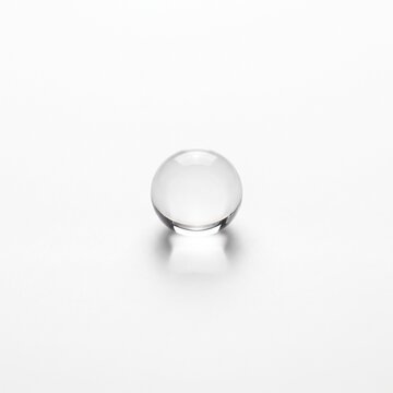 Minimalist glass sphere on seamless white background, clear crystal orb isolated, transparent glass ball object for graphic design concepts