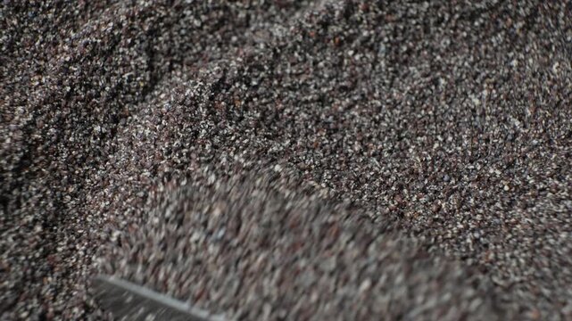 Spreading ground poppy seeds revealing texture macro shot