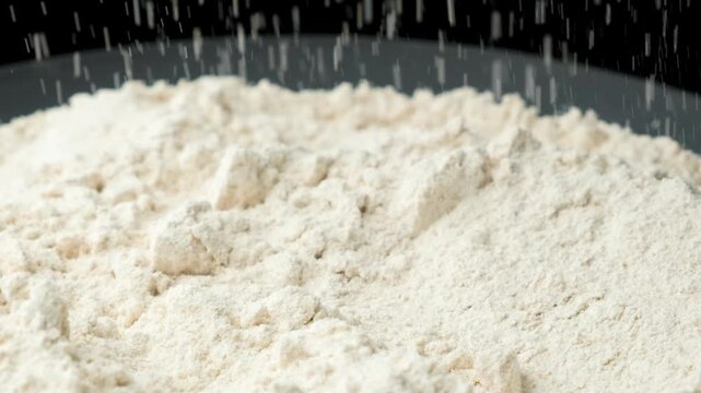 Organic spelt flour sifting and falling in slow motion macro close up.