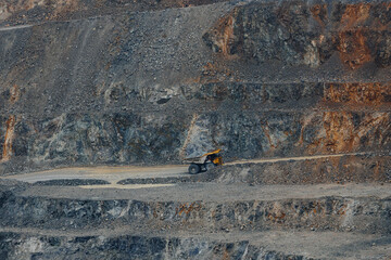 Terraced open pit quarry with heavy dump truck on haul road for industrial background and mining operations for excavation planning © Parilov