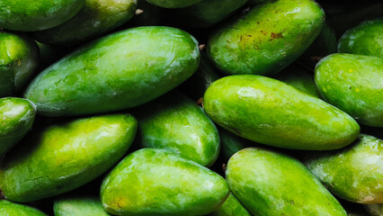 Fresh green mangoes texture background, healthy organic food, agriculture, local market displays, and culinary designs. © Handycraft