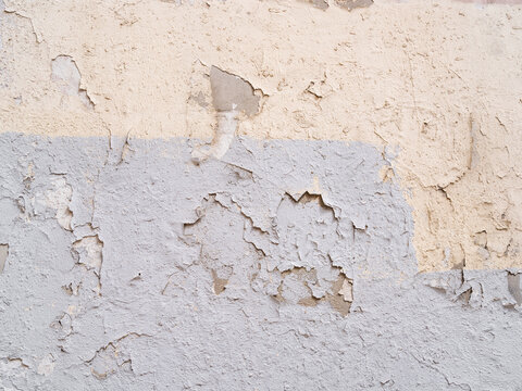 Grobe verputzte Wand oder Mauer mit Abplatzungen, gestrichen in den Farben beige und blau  als Hintergrund