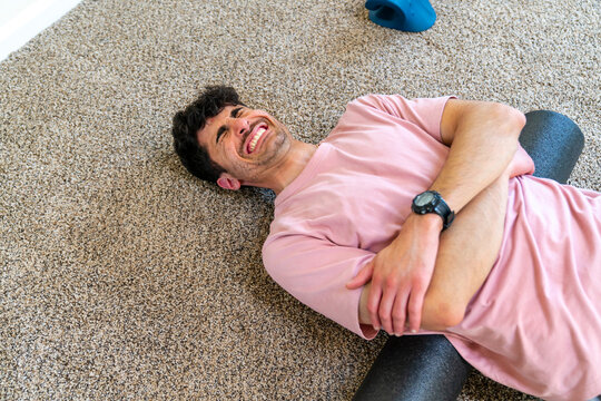 man using foam roller stretching back