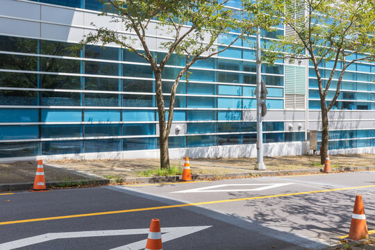 Modern Office Building Exterior View with Street and Traffic Cones