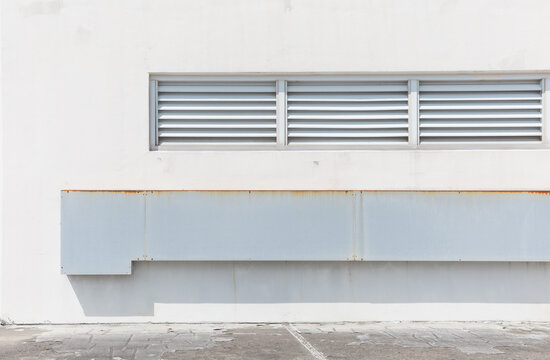 White Building Wall with Louver Vent and Weathered Metal Structure