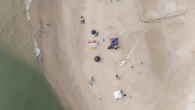 Beach Scene With Umbrellas, Boats, and People During Daytime