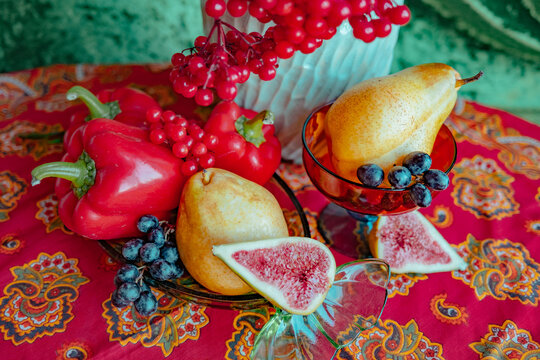 Fruit arrangement on colorful tablecloth with red and green tones
