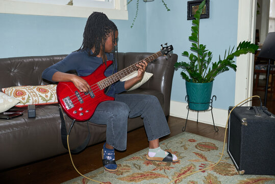 Girl practiging bass guitar