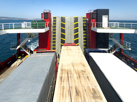 Freight Trucks Transported On Car Ferry Deck Facing Ramp