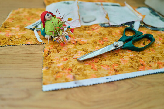 Sewing Supplies With Pinking Shears and Pin Cushion on Floral Fabric