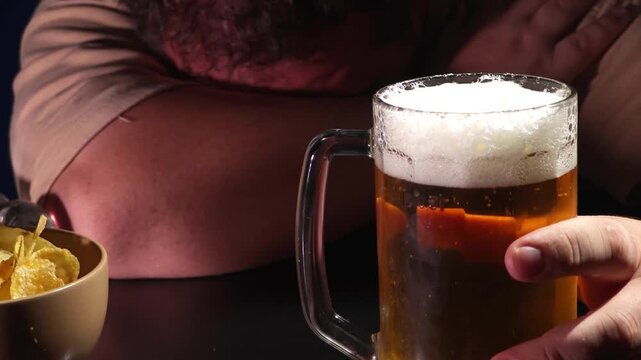 Depressed  man sitting at a kitchen counter with a beer mug, struggling with alcohol addiction and mental health issues