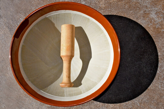 A traditional Japanese ceramic grinding bowl called a  suribachi with an interior surface of fine, jagged grooves (kushime) and pestle 