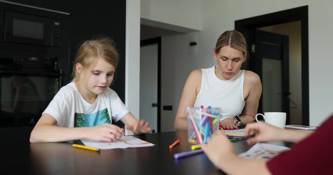 Mother with two children playing drawing game together at home. Quality time