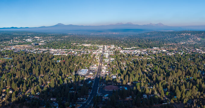 An aerial drone view showing the town of Bend and the shadow of prominent Pilot Butte located in the state of Oregon.