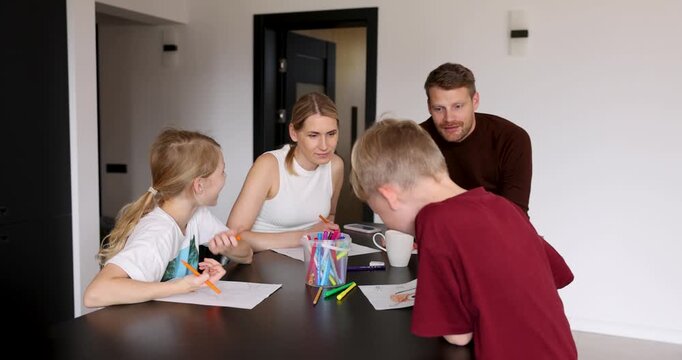 Happy family with two children playing drawing game together at home. Quality time