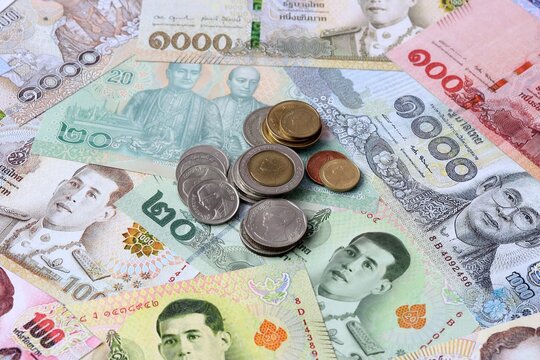 Thai baht money notes and coins on table. Thailand cash bills of THB currency close up