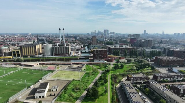 Drone view of The Hague city skyline with power station and sports fields in foreground