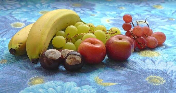  Still Life - Fruit composition with bananas, grapes, plums, and chestnuts
