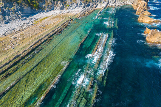 Aerial view of dramatic cliffs, sea stacks, and turquoise water along Costa Quebrada coastline, Cantabria, Northern Spain