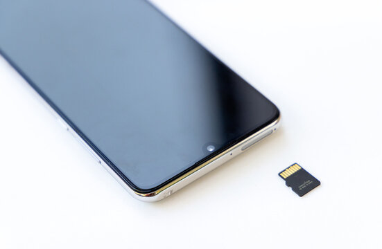 Modern smartphone with tiny memory card on white background