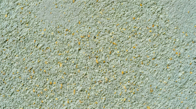 Abstract grey wall texture with small yellow square shapes scattered across the rough surface