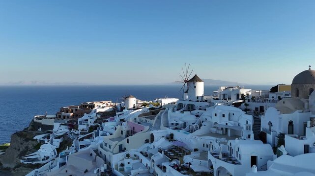 Panoramic aerial view of the famous white buildings and windmills in Oia Santorini