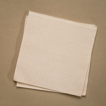blank cocktail napkin against textures art paper