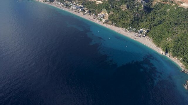Dhermi beach along the stunning Ionian coast in Albania, aerial drone view. Panoramic bird's eye view of the beautiful Dhermi coastline featuring blue sea and pristine beaches.