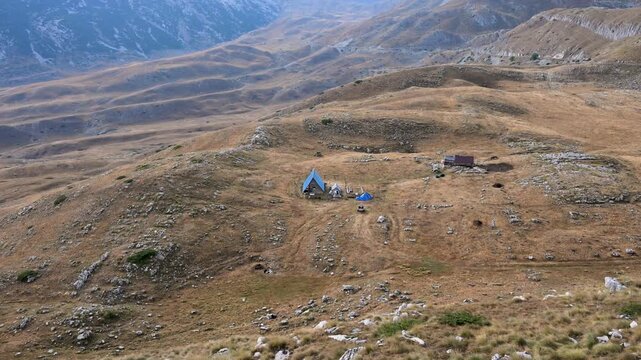 High altitude pastoral huts and stables on a mountain plateau. Traditional wooden livestock huts and barns on a highland plateau.