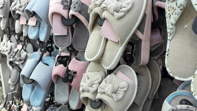 A variety of stylish slippers are neatly arranged on display in a bright store. Different colors and styles make the collection visually appealing, showcasing modern fashion and comfort.