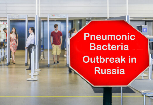 Airport security checkpoint with a red warning sign reading Pneumonic Bacteria Outbreak in Russia in October 2026