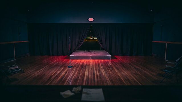 Empty Performance Stage with Microphone and Curtain in a Theater Setting