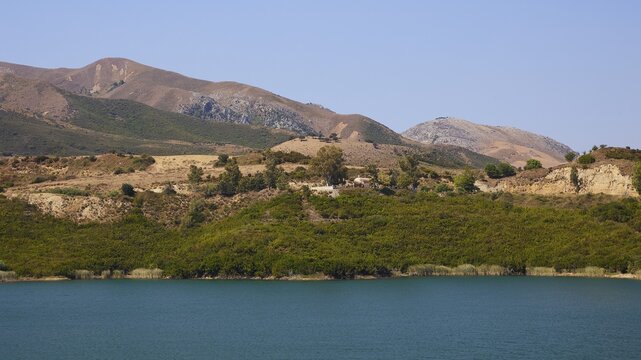 Potamon Reservoir, Calm lake surrounded by green hills under blue sky, Amari Basin, Amari, Central Crete, Greek Islands, Greece