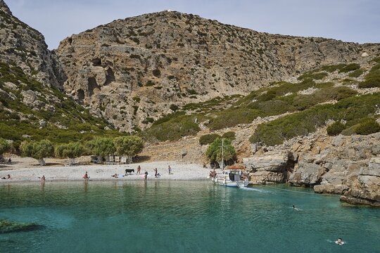Palatia Beach, Palatia, A quiet bay surrounded by mountains, with a boat and swimmers in the clear blue water, boat tour Saria, Saria Island, Karpathos, Dodecanese, Greek Islands, Greece