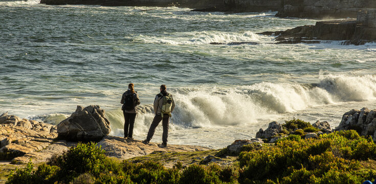 large pounding waves and spray hitting rocky cliffs of Hermanus South African coastline