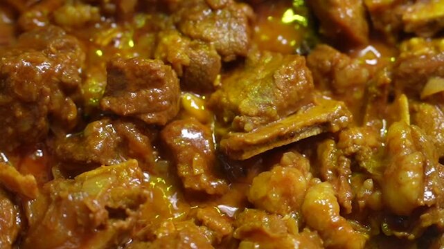 Closeup of a delicious and spicy mutton curry dish cooked in a rich, flavorful gravy with traditional indian spices and tender meat pieces