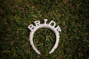 Bride headband with pearl details resting on green grass, ready for celebration © Ana