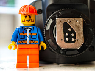 Naklejka premium Russia, St. Petersburg, August 8, 2020. Lego man standing next to flash hot shoe, creative and fun scene