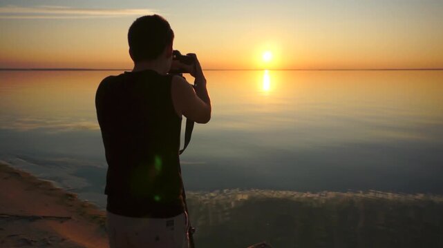 Man taking photos at sunset