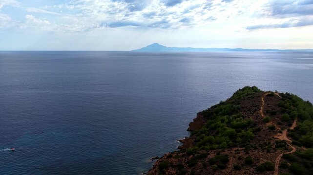 Calm Aegean Sea and forested headland, mountain on horizon, Thassos