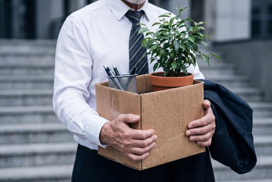 Businessman with box cardboard packing personal items after losing jobs. Failure businessman standing at front of building. Your fired Unemployed Jobless People Crisis