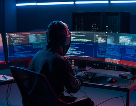 Hacker informatique devant plusieurs &eacute;crans dans un centre de cybers&eacute;curit&eacute;