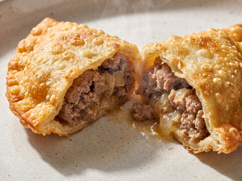 Deep fried crispy meat cheburek turnover cut in half with juicy filling