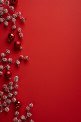 Red Christmas vertical background with snowy berry branches and red ornaments for holiday greetings © ActionGP