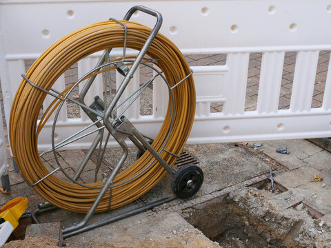 A cable pulling device (often referred to as a pipe puller or fiber-optic pulling tape on a mobile reel) used to pull cables or pipes through underground utility networks